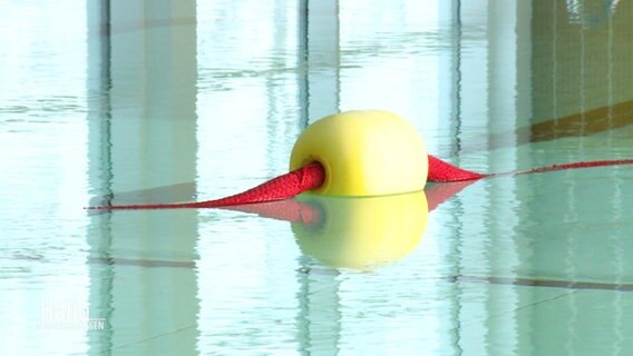 Eine Boje in einem Hallenbad liegt ruhig im Wasser. © Screenshot 