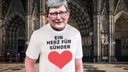 Kardinal Woelki hat ein Shirt mit der Aufschrift "Ein Herz für Sünder". © Screenshot 