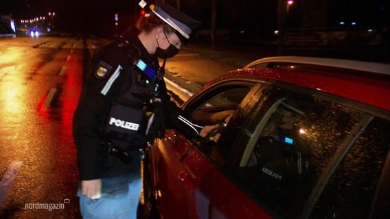 Eine Polizistin misst bei einem Autofahrer seinen Atemalkoholwert. © Screenshot 