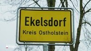 Ortseingangsschild "Ekelsdorf", Kreis Ostholstein. © Screenshot 