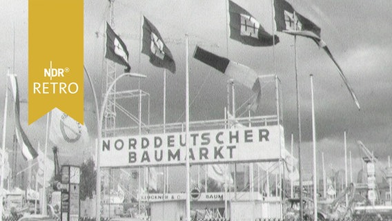 Eingangsportal mit Fahnen und Überschrift "Norddeutscher Baumarkt" (1963) © Screenshot 