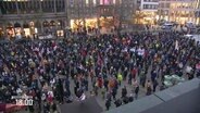 Menschen stehen bei einer Mahnwache in Hannover. © Screenshot 