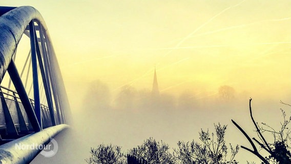 Ein stimmungsvolles Foto mit einer Brücke im Nebel. © Screenshot 