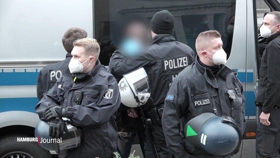 Polizisten führen einen festgenommen Demonstranten ab. © Screenshot 