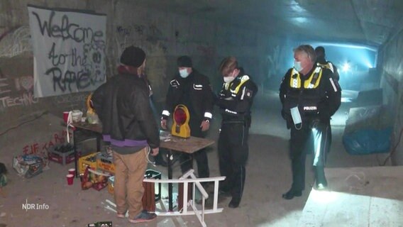 Polizeibeamte kontrollieren eine Person in einem Tunnel. © Screenshot 