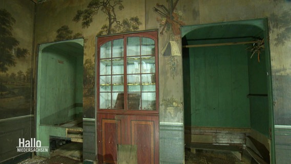 Blick in ein Zimmer mit einer handgemalten Tapete an den Wänden. © Screenshot 