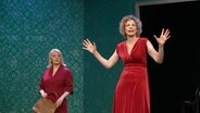 Zwei Frauen in roten Kleidern auf einer Bühne (Szenenbild aus "Stella" in den Hamburger Kammerspielen) © Screenshot 