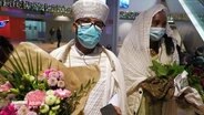 Ein Paar aus Eritrea mit Atemschutzmasken und Blumen in den Händen © Screenshot 