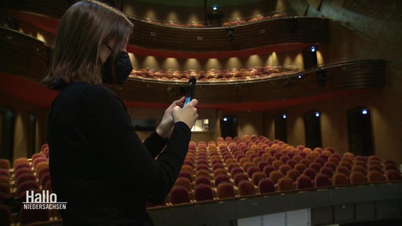 Eine Frau film ein Handy-Video in einem Theater © Screenshot 
