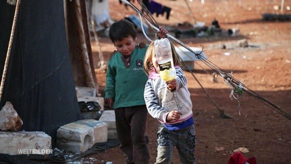 Zwei Kinder spielen mit einer leeren Flasche. © Screenshot 