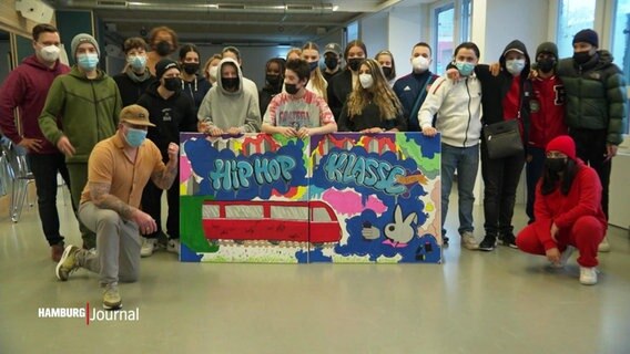 Die Schüler und Lehrer der "HipHop-Klasse" posieren mit einem selbstgemalten Graffito © Screenshot 