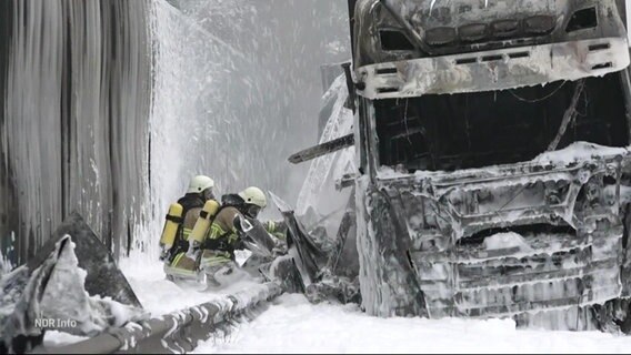 Ein ausgebrannter LKW wird mit Schaum gelöscht © Screenshot 