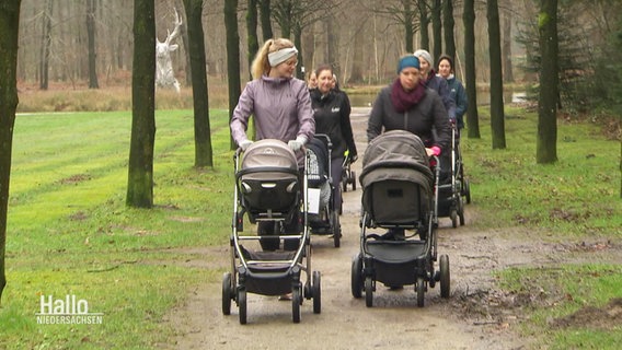 Frauen mit Kinderwägen laufen durch einen Park. © Screenshot 