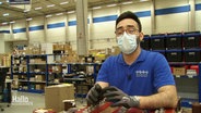 Der Spanier Eric Campos Ruiz bei seiner Arbeit in der Logistikhalle eines Technikdienstleisters in Nörten-Hardenberg. © Screenshot 