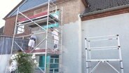 Handwerker sanieren eine Fassade © Screenshot 