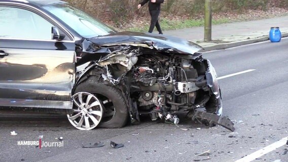 Auf einer Straße steht ein schwarzes Auto mit einem Totalschaden an der vorderen rechten Flanke. © Screenshot 