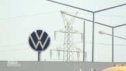 Auf dem Dach eines Industriegebäudes prangt das VW-Logo, im Hintergrund ein Strommast. © Screenshot 
