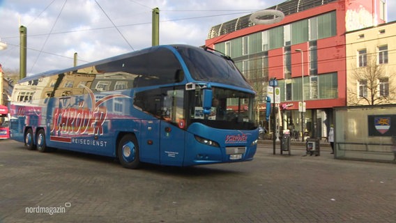 Ein blauer Reisebus auf einem Platz © Screenshot 