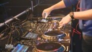 Die Hände eines DJs bedienen ein Mischpult. © Screenshot 