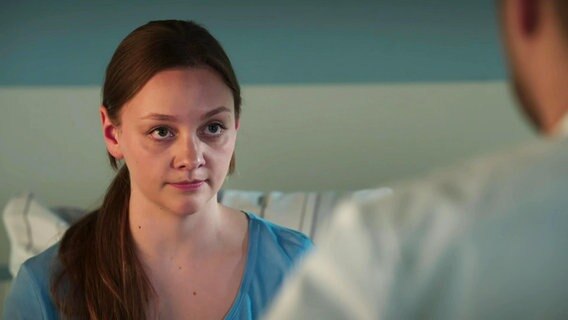 Eine junge Frau sitzt in einem Krankenbett. © Screenshot 