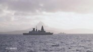 Marineschiffe auf dem Meer, im Hintergrund sieht man einen schneebedeckten Berg. © Screenshot 