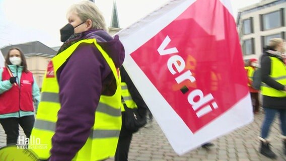 Eine streikende Person mit ver.di Flagge. © Screenshot 