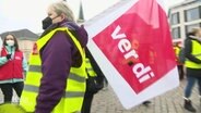 Eine streikende Person mit ver.di Flagge. © Screenshot 