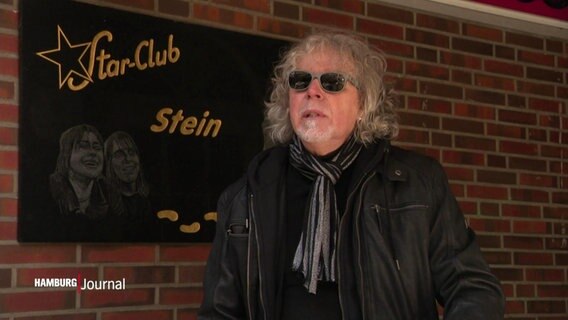 Autor Klaus Spieldenner mit Sonnenbrille und Lederjacke neben dem Gedenkstein des Star-Club in Hamburg. © Screenshot 