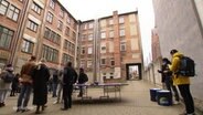 Mehrere Menschen stehen auf dem Hof des Kreativquartiers in Schwerin. © Screenshot 