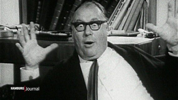 Eine schwarzweiße Aufnahme von Heinz-Erhardt. Er reißt erstaunt die Augen auf. © Screenshot 