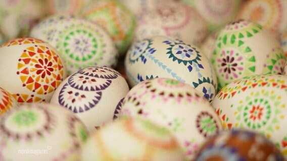 Viele, mit bunten Mustern bemalte Eier liegen dicht bei dicht nebeneinander. © Screenshot 