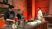 Cem und Ingrid Strässer kochen. Steffen Henssler schaut zu. © Screenshot 