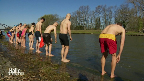 Mehrere Menschen in Badekleidung kurz vor dem Sprung in den Mittellandkanal. © Screenshot 