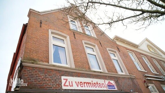 Ein Wohnhaus mit einem Banner an der Außenfassade der "Zu vermieten" liest. © Screenshot 