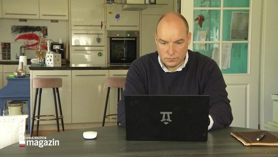 Ein Mann sitzt hinter einem Laptop. © Screenshot 