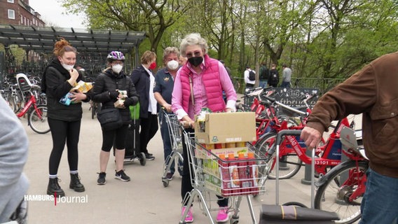 Menschen geben bei einer Spendenaktion von NDR 90,3 und dem Hamburg Journal Lebensmittel für die Hamburger Tafel ab. © Screenshot 