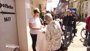 Menschen in der Fußgängerzone unterschreiben eine Petition. © Screenshot 