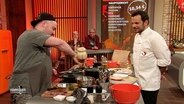 Steffen Henssler sieht einem Kandidaten beim Kochen zu © Screenshot 