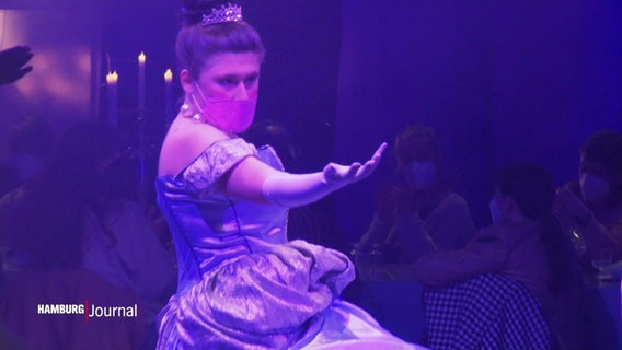 Eine Darstellerin in einem Prinzessinnenkostüm streckt wie bei einem Balltanz eine Hand aus. © Screenshot 
