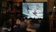 Menschen gucken einen Film auf einer Leinwand. © Screenshot 