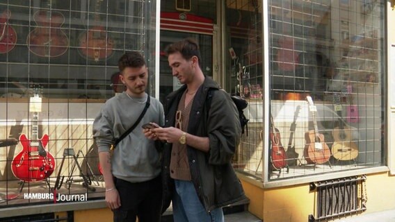 Zwei junge Männer vor einem Geschäft. © Screenshot 