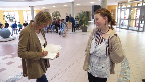 Die Autorin Kirsten Boie signiert das Buch einer Schülerin. © Screenshot 