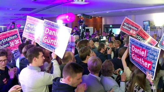 CDU-Anhänger feiern mit Plakaten © Screenshot 