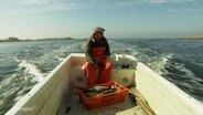 Mann sitzt in einem Fischerboot. © Screenshot 