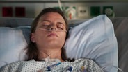 Eine junge Frau liegt in einem Krankenhausbett. © Screenshot 