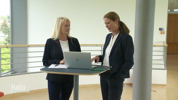 Zwei Frauen stehen an einem Tisch und diskutieren. © Screenshot 
