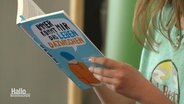 Eine Schülerin liest aus einem Buch vor. © Screenshot 
