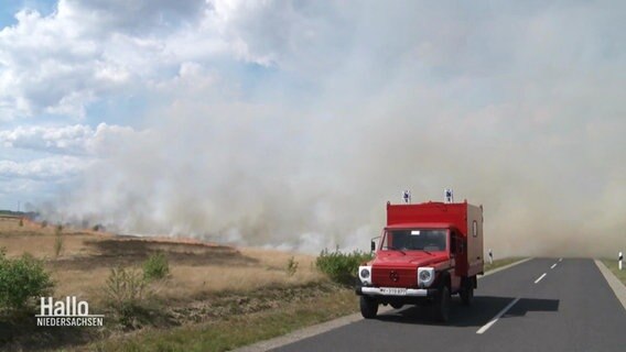Ein Feuerwehrwagen der Bundeswehr steht vor einem qualmenden Feld. © Screenshot 