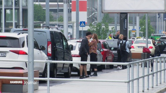 Zwei Menschen küssen sich neben parkenden Autos. © Screenshot 