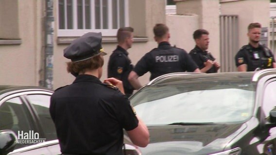 Polizistinnen und Polizisten stehen vor dem Schulgebäude. © Screenshot 